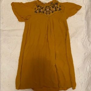 A gold dress with flower design at the top